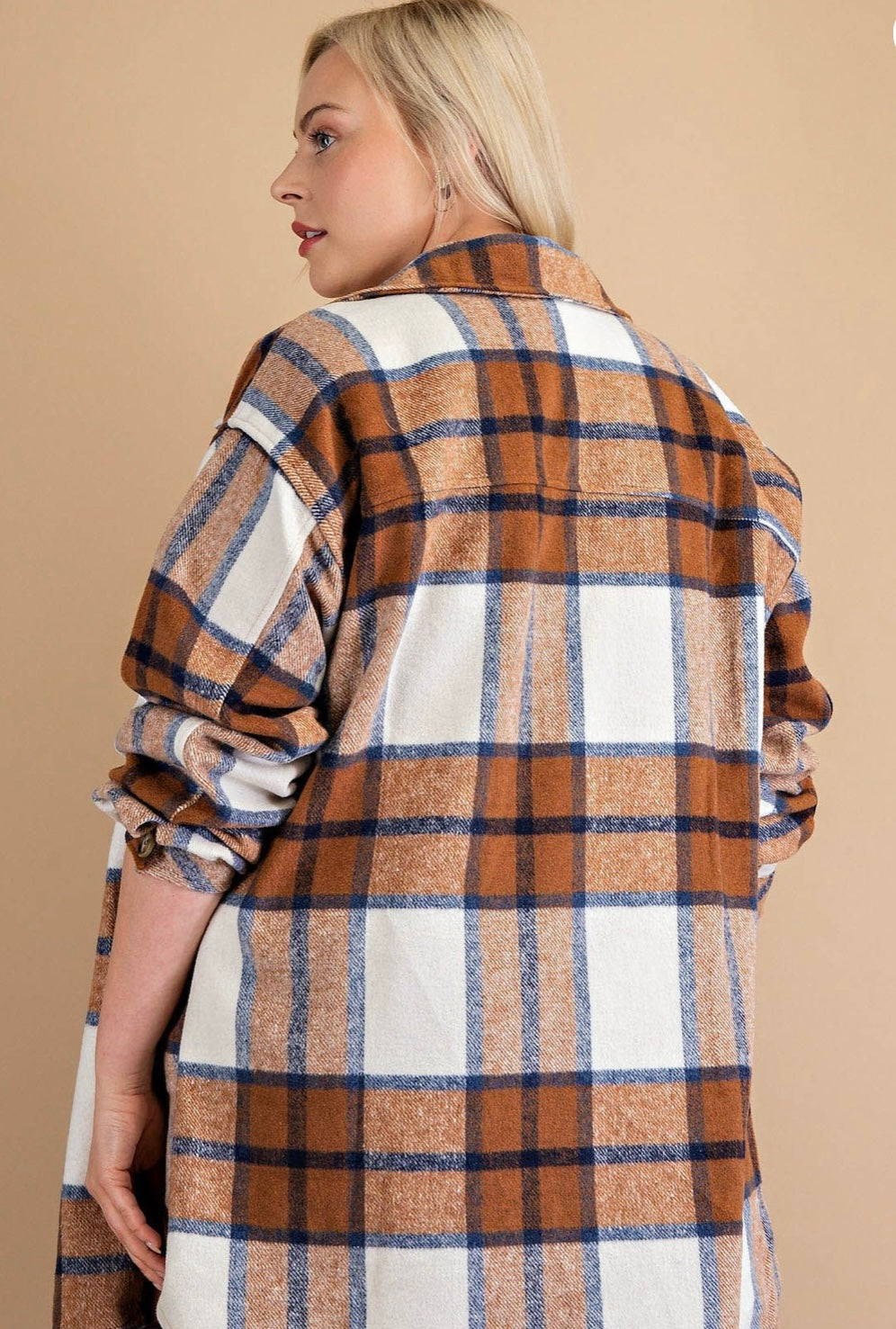 A woman models a Brushed Plaid Button Down Shirt - PLUS in shades of mocha mix and white, looking over her shoulder with a profile view of her face visible.