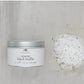 Open tin labeled "Coarse Black Truffle Salt" with infused coarse salt crystals. Available in 2 oz and 4 oz sizes.