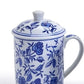 White ceramic mug with handle, matching lid, blue rose and leaf pattern. Available sizes: 53592-20. Classic blue and white design.