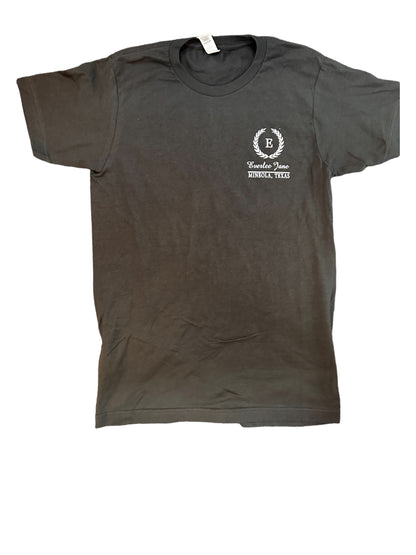A charcoal gray Everlee Jane Tshirt with a small white logo on the left chest area that includes an emblem and the text "Lindale, Texas." The shirt is displayed flat on a white.