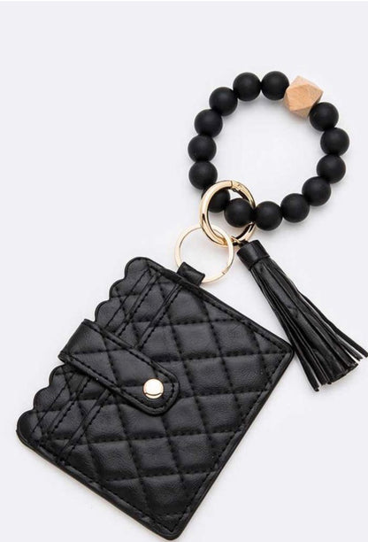 Black quilted card case with snap, beaded bracelet, gold ring, tassel. Nickel compliant hardware. Sizes: S, M, L.