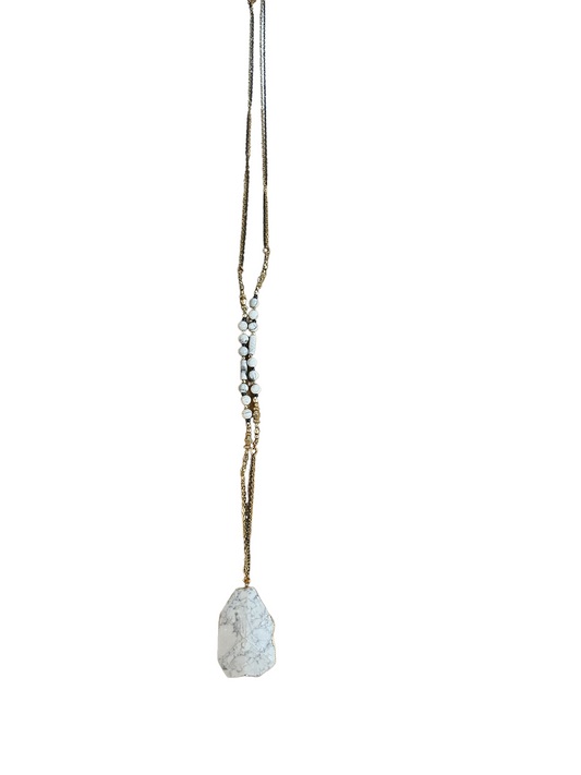 Gold chain with small white beads and a large, uniquely shaped white granite pendant with gray veining. Available in S, M, L.