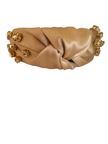 Tan satin headbands with a twisted knot and large gold gemstones on the sides. Available in small, medium, and large sizes.